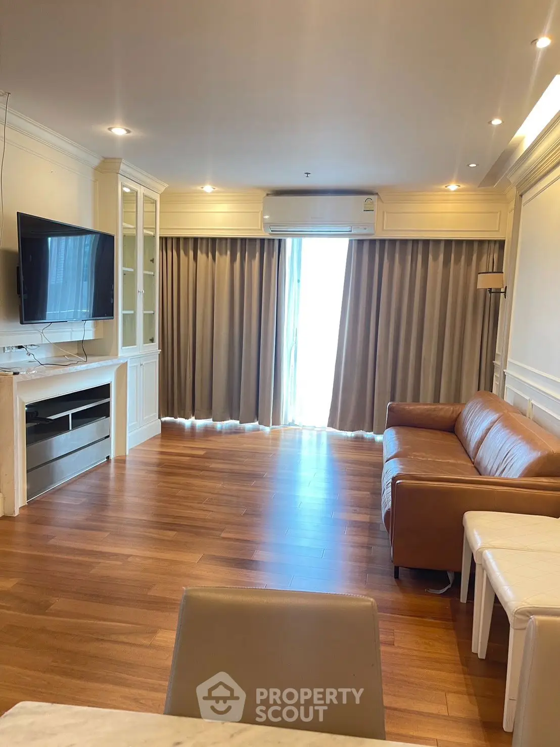 Spacious living room with wooden flooring and modern furnishings in a stylish apartment.