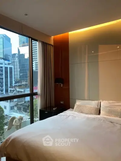 Luxurious bedroom with city view and modern design in high-rise building.