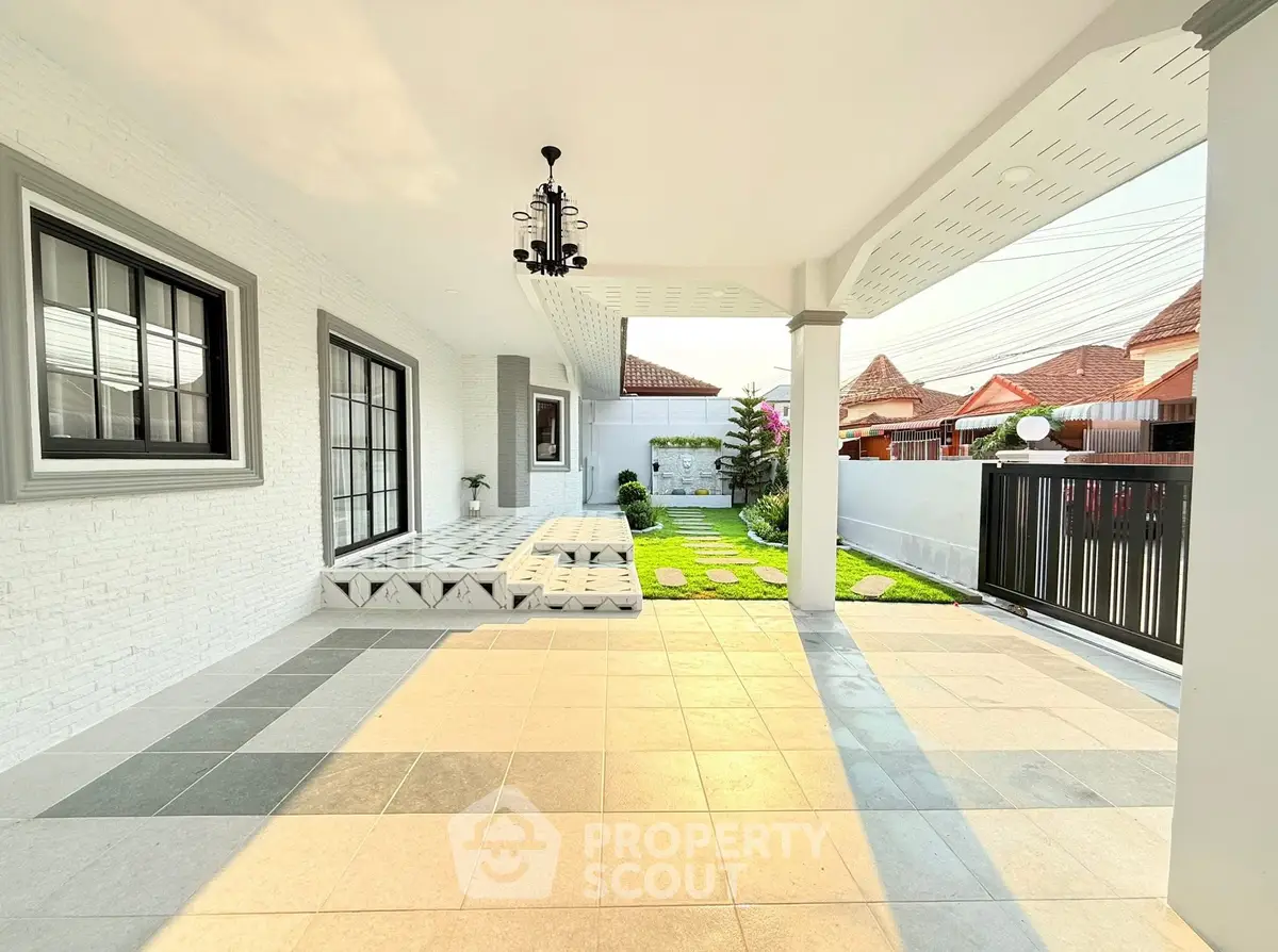 Spacious modern patio with elegant tiles and lush garden view in a suburban home.