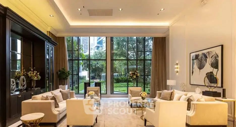 Luxurious living room with large windows and elegant decor overlooking a lush garden.