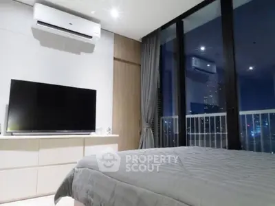 Modern bedroom with city view, featuring sleek design and large windows for natural light.