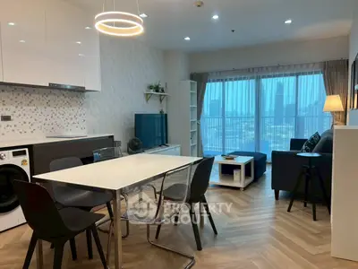 Modern open-plan living room with dining area and city view, featuring stylish furniture and elegant lighting.