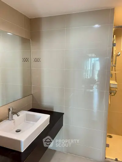Modern bathroom with sleek sink and glass shower enclosure