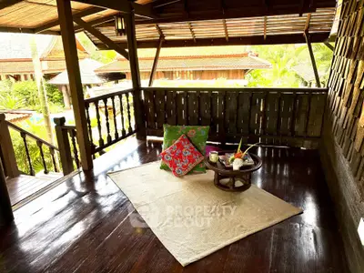 Charming wooden balcony with cozy seating and lush garden view, perfect for relaxation and enjoying nature.