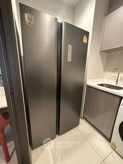 Modern kitchen with sleek refrigerator and washing machine