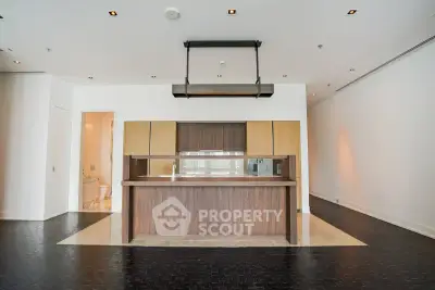 Luxurious modern kitchen with sleek island and open layout in upscale apartment.