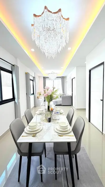 Elegant dining area with modern chandelier and stylish table setting in a bright, open-concept living space.