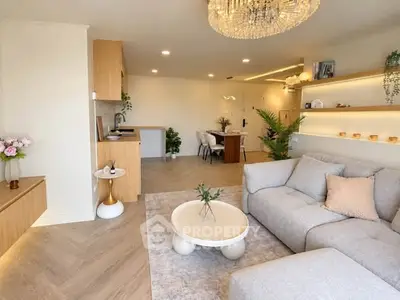 Modern living room with open kitchen, elegant decor, and cozy seating area