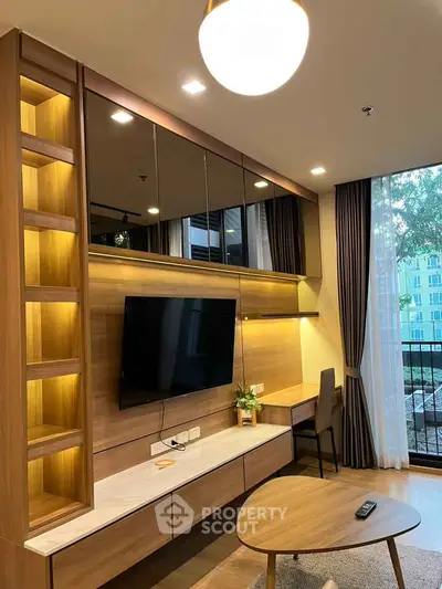 Modern living room with built-in shelving, TV, and large window with balcony view.