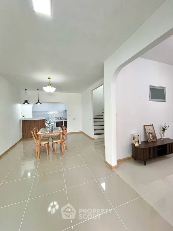 Spacious open-plan living area with modern kitchen and elegant dining setup.