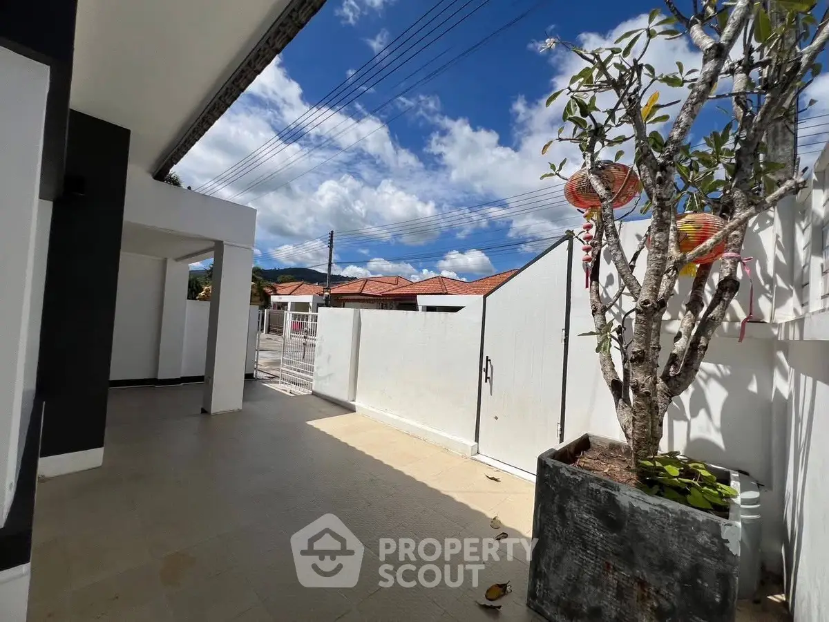 Charming outdoor patio with potted tree and sunny sky, perfect for relaxation and gatherings.