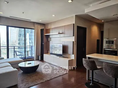 Modern living room with city view, stylish furniture, and open kitchen layout in a high-rise apartment.