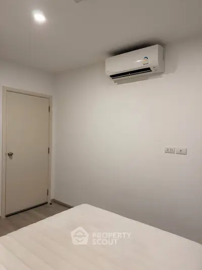 Minimalist bedroom with air conditioning and neutral tones