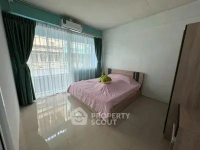 Spacious bedroom with large window and modern decor
