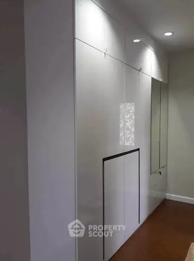 Sleek modern storage unit with glossy white finish and integrated lighting, perfect for maximizing space.