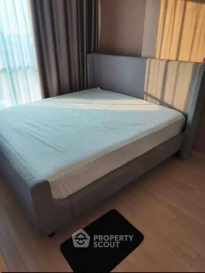 Modern bedroom with stylish grey bed and natural light