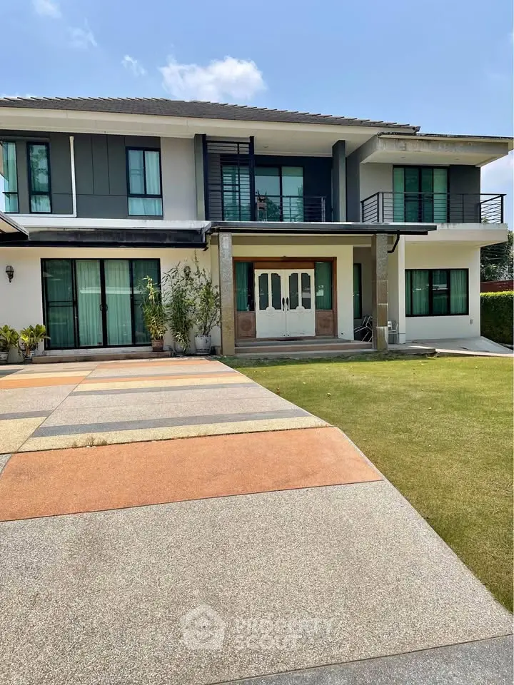 Stunning modern two-story house with spacious driveway and lush green lawn, perfect for family living.