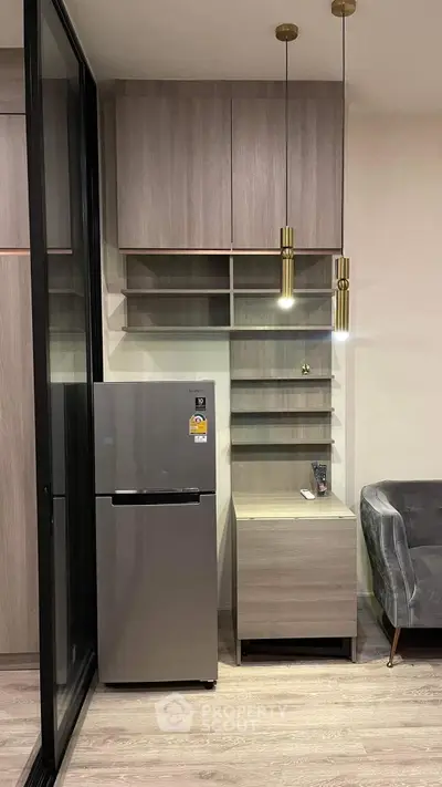 Modern kitchen corner with sleek fridge and stylish shelving in contemporary apartment.