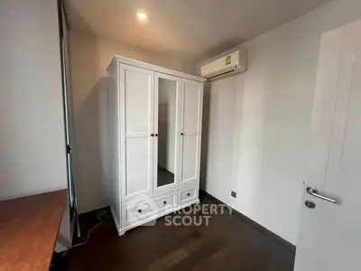 Modern bedroom with sleek wardrobe and air conditioning unit, perfect for comfortable living.