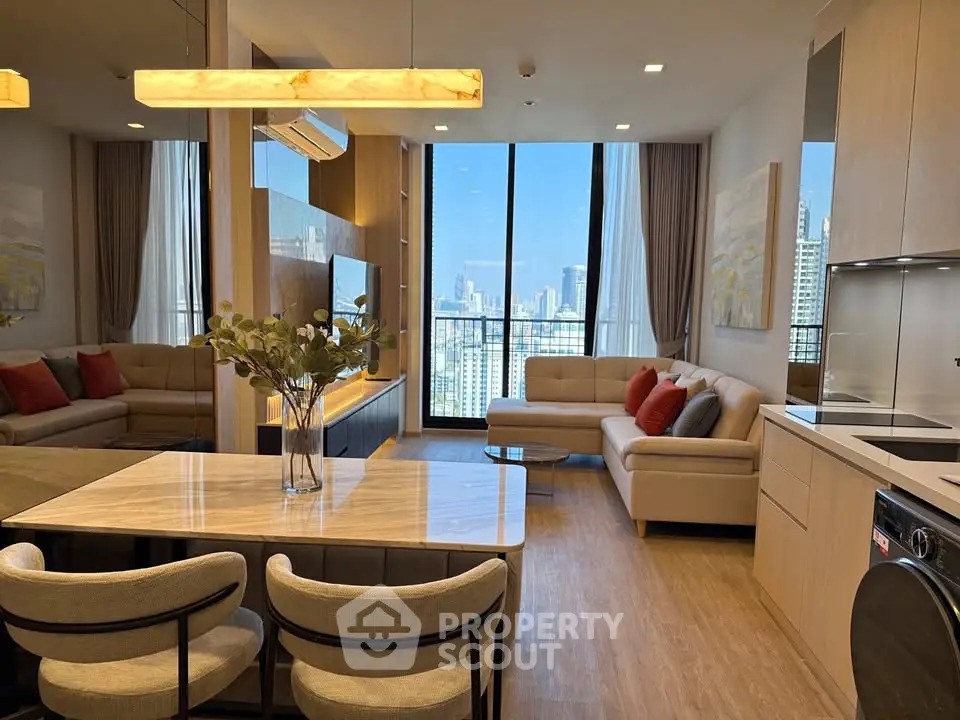 Luxurious modern living room with city view, open kitchen, and elegant decor in high-rise apartment.