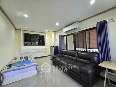 Spacious living room with leather sofa and large windows in modern apartment
