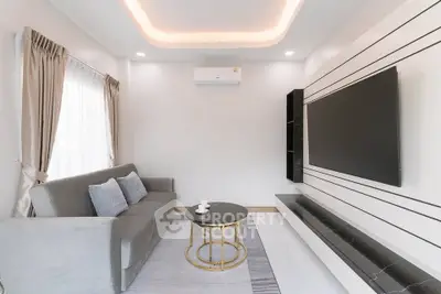 Modern living room with sleek design, featuring a large TV, stylish sofa, and elegant lighting.
