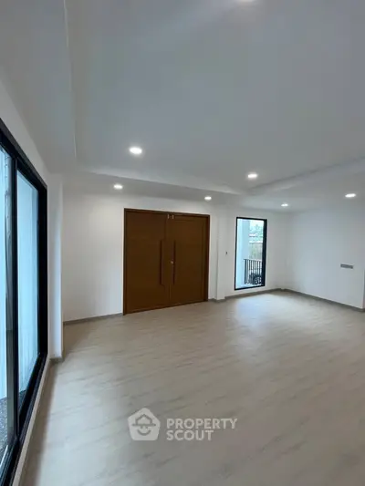 Spacious modern living room with large windows and wooden flooring