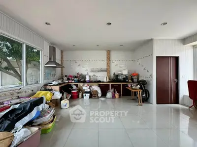 Spacious kitchen with open layout and ample natural light, featuring modern appliances and tiled flooring.