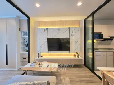 Modern living room with sleek TV wall and open kitchen layout