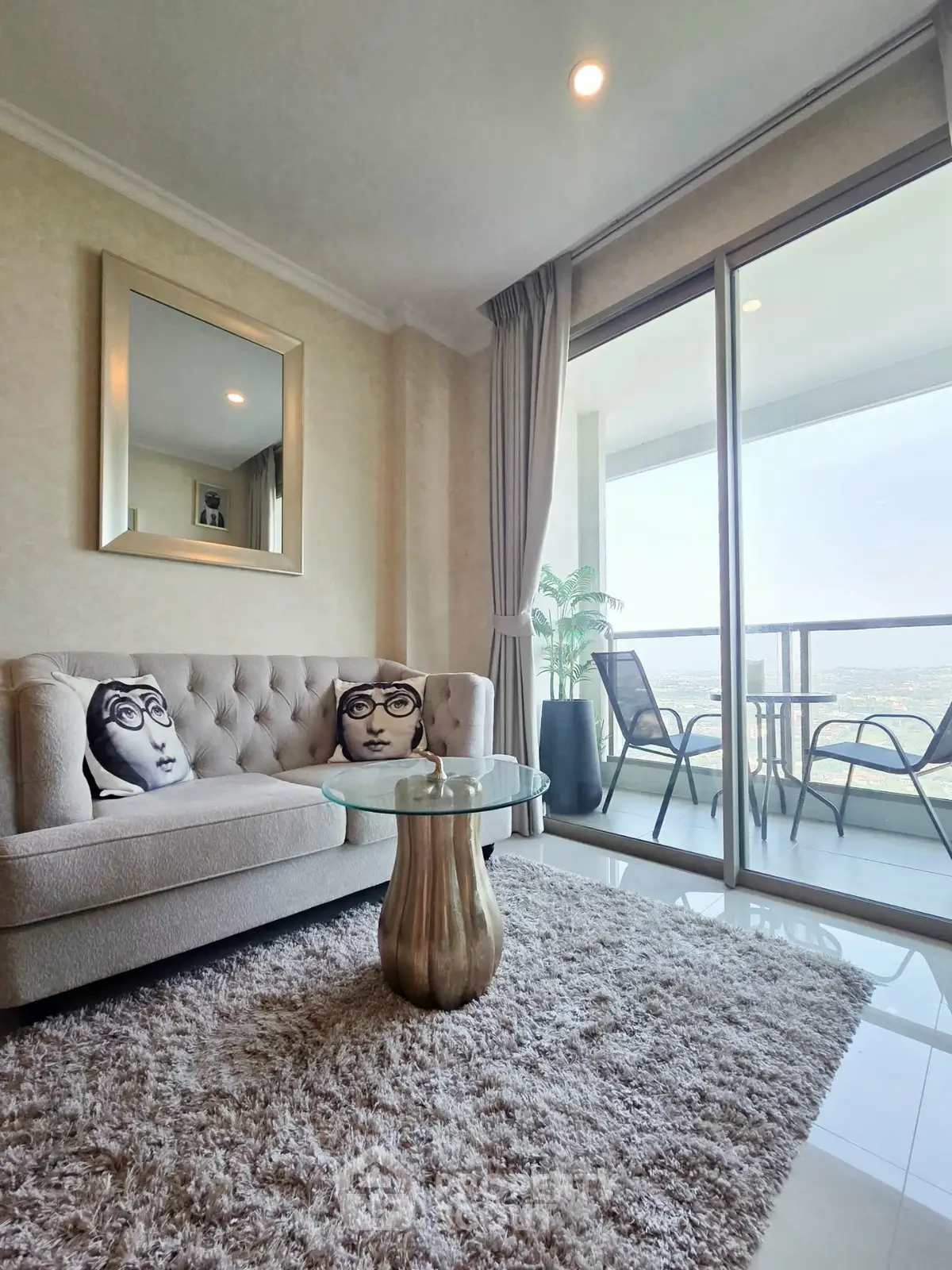 Luxurious living room with plush sofa, chic decor, and stunning balcony view.