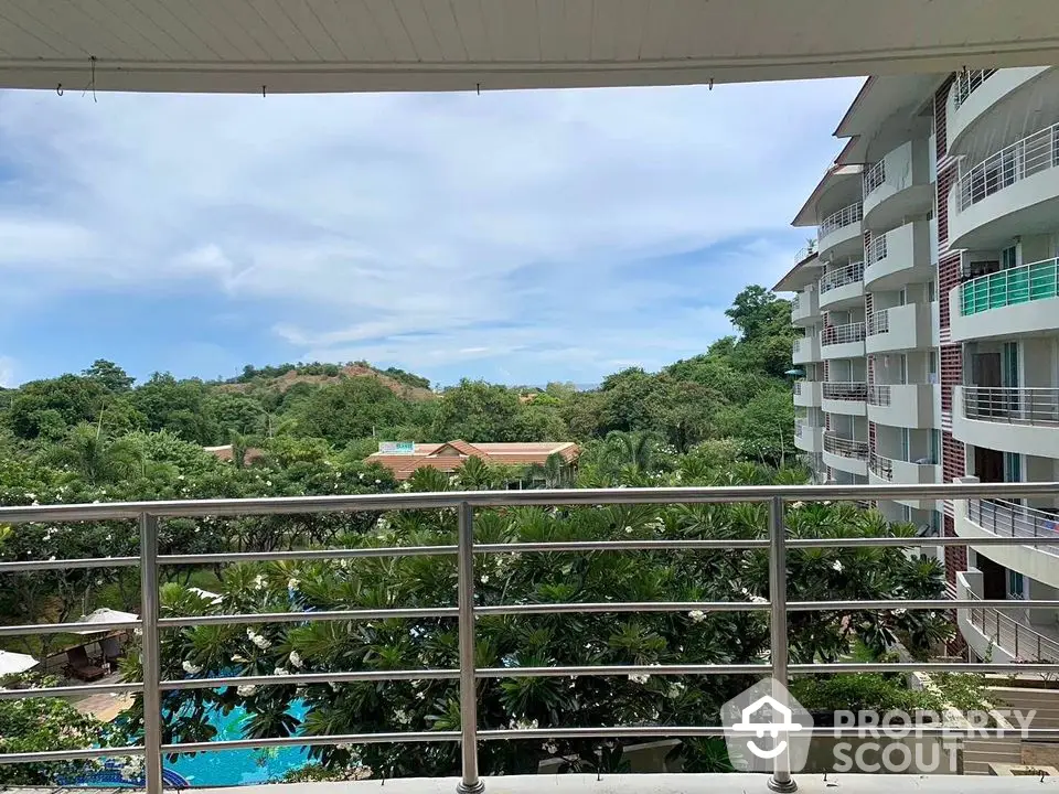 Stunning balcony view overlooking lush greenery and modern building architecture.