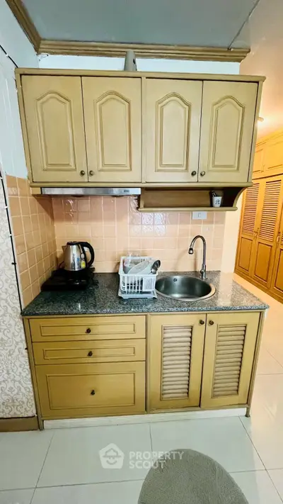 Charming kitchen with wooden cabinets and granite countertop, featuring a cozy closed layout.