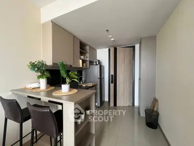 Modern kitchen with sleek design, featuring a breakfast bar and stainless steel appliances.