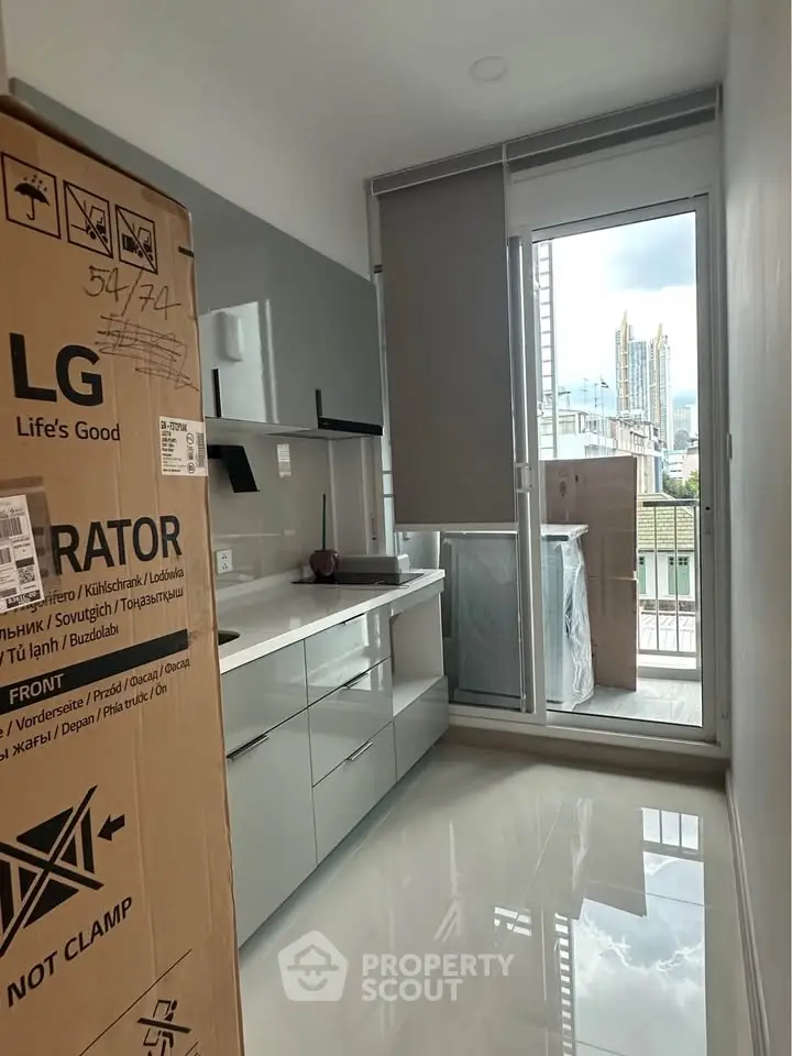 Modern kitchen with sleek cabinets and city view from balcony.