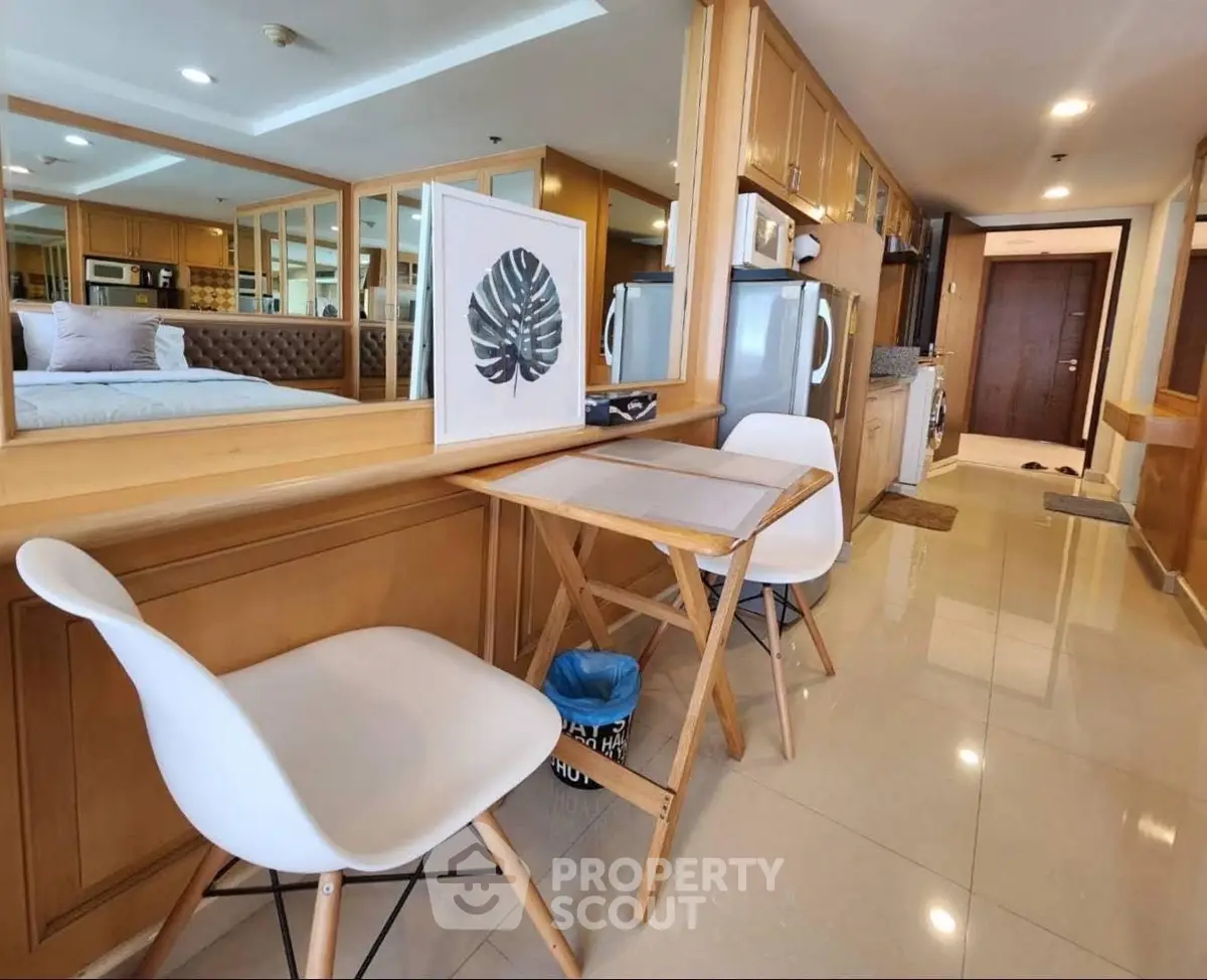 Modern apartment interior with dining area and kitchen, featuring sleek design and cozy ambiance.