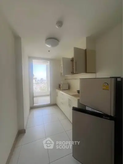 Modern kitchen with sleek appliances and city view from window, perfect for urban living.