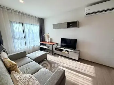 Modern living room with sleek furniture and natural light, featuring a cozy sectional sofa and wall-mounted TV.