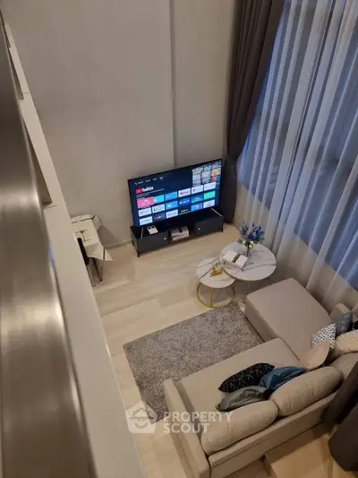 Modern living room with cozy sectional sofa and large TV, perfect for relaxation.