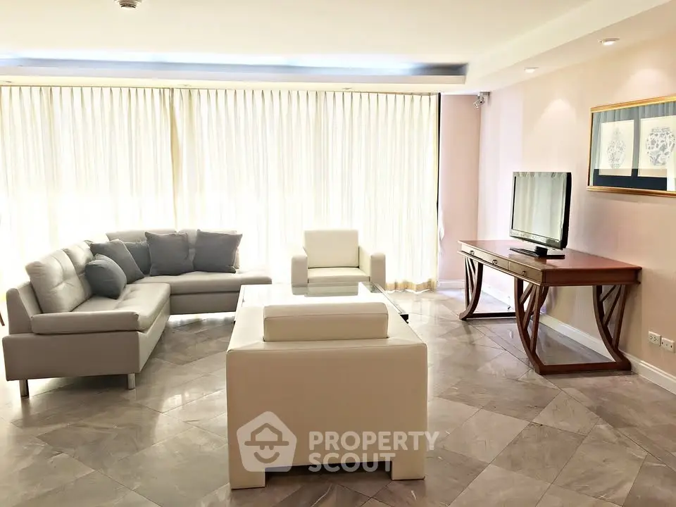 Spacious and bright living room with modern furniture and large windows.