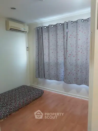 Cozy minimalist bedroom with air conditioning and floral curtains