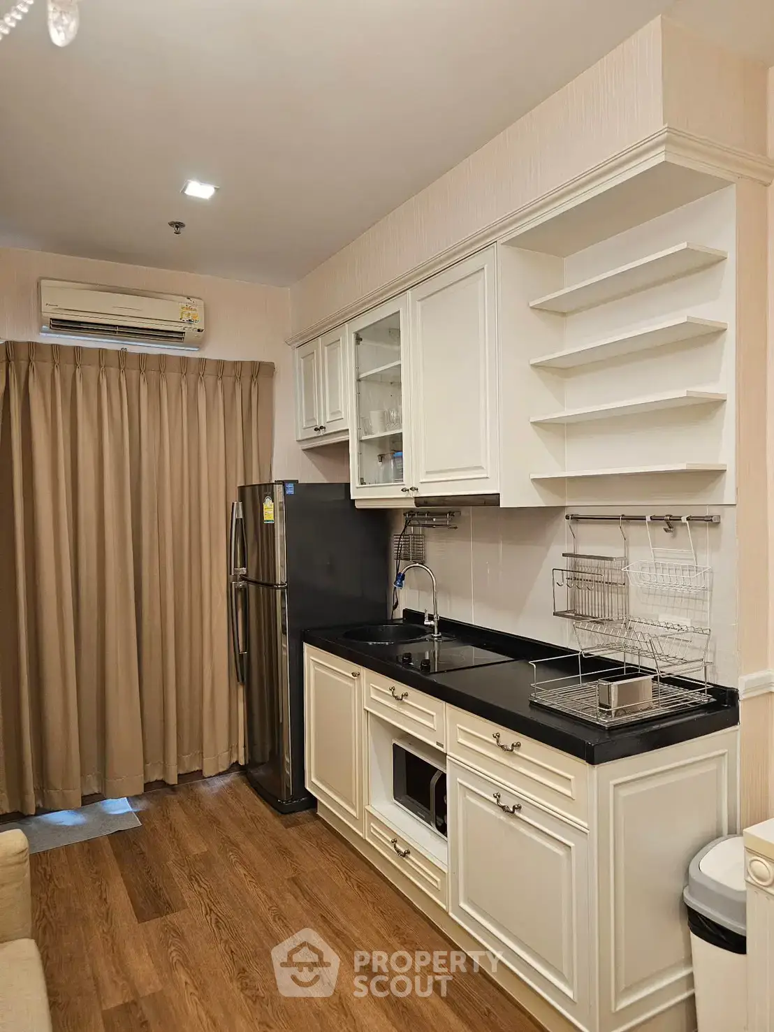 Charming kitchen with elegant cabinetry and modern appliances in a cozy apartment setting.