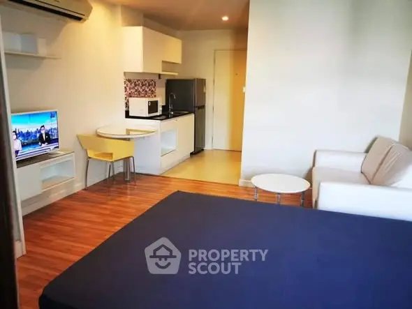 Modern studio apartment with cozy living area and compact kitchen.