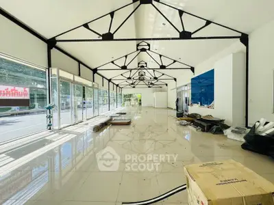 Spacious commercial space with large windows and high ceilings, ideal for retail or office use.