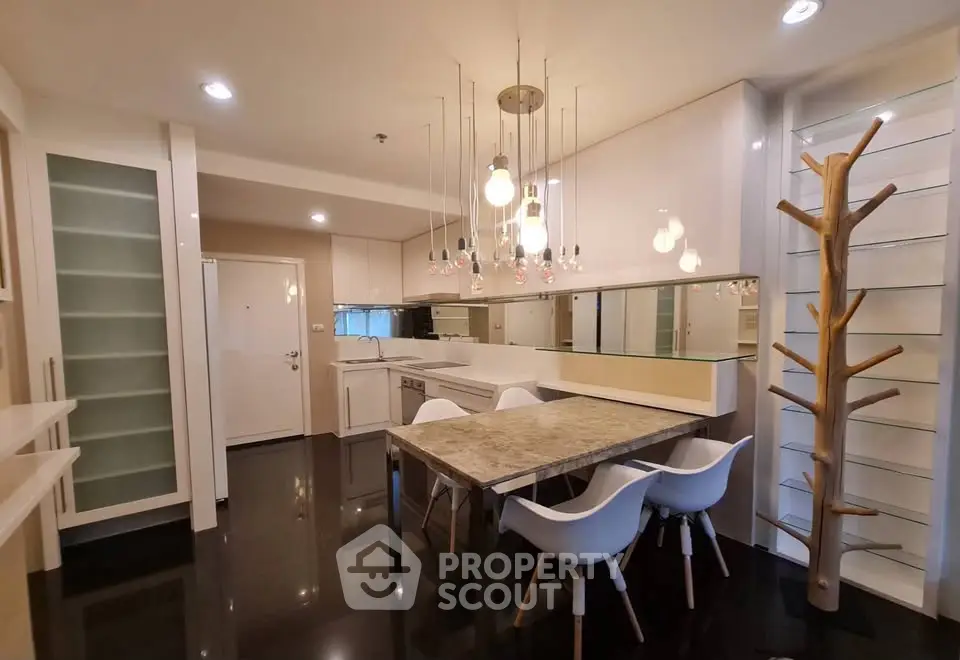 Modern kitchen with sleek design, featuring elegant lighting and a stylish dining area.
