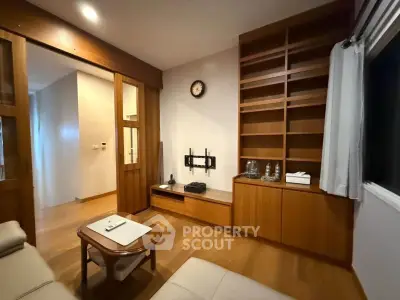 Cozy living room with wooden shelves and modern decor in a stylish apartment.