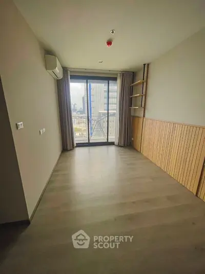 Spacious modern room with large window and city view, ideal for versatile living space.