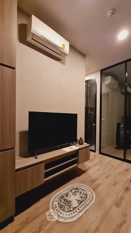 Modern living room with sleek wooden flooring and stylish TV setup