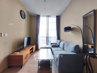 Modern living room with stylish furniture and large window offering natural light.