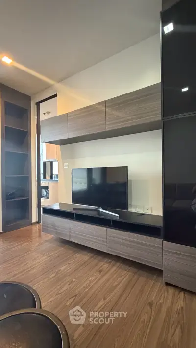 Modern living room with sleek wooden flooring and contemporary TV unit