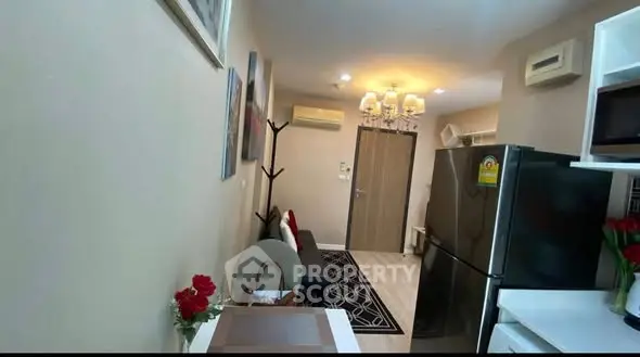 Cozy living room with modern decor and stainless steel appliances in a compact apartment.